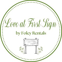 Love At First Sign logo — a hand-drawn wooden yard sign with daisies